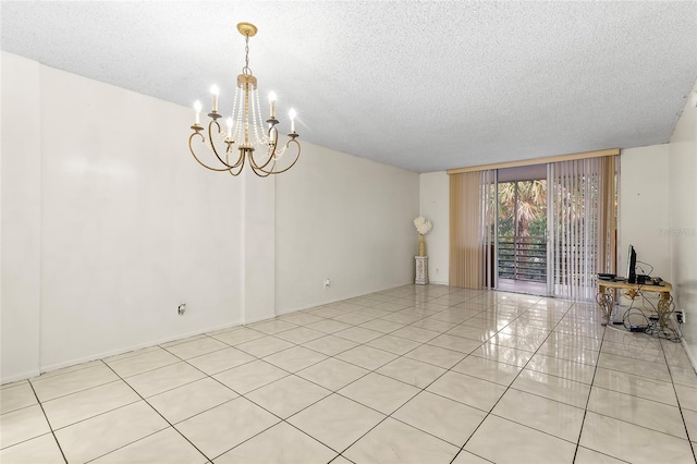 empty room featuring an inviting chandelier, a textured ceiling, and light tile patterned floors