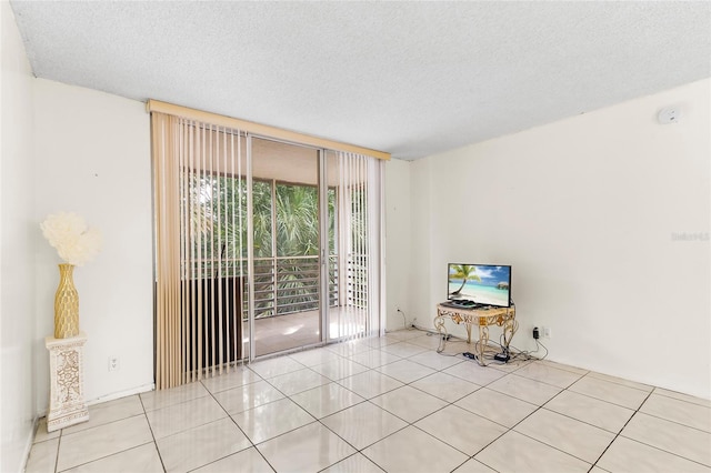 interior space featuring light tile patterned flooring and a textured ceiling