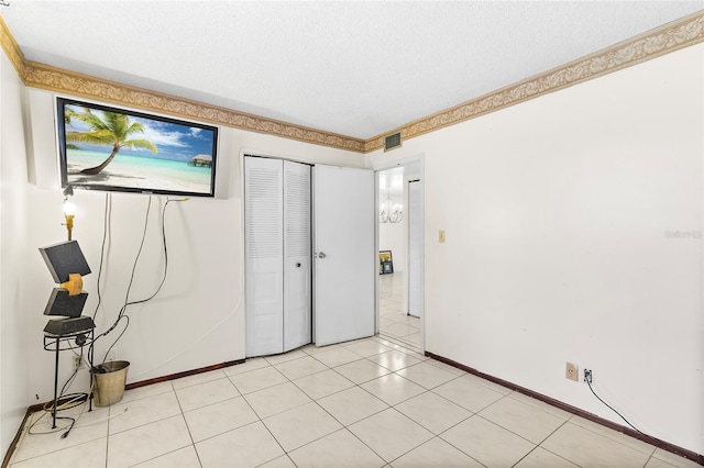 unfurnished bedroom featuring a closet, a textured ceiling, and light tile patterned floors