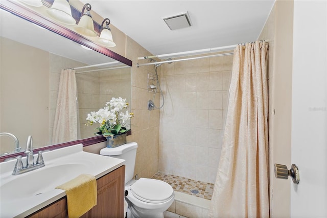 bathroom featuring toilet, curtained shower, vanity, and tile patterned flooring