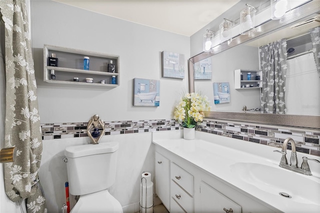 bathroom with tile walls, vanity, and toilet