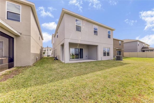 rear view of house with a yard, cooling unit, and a patio