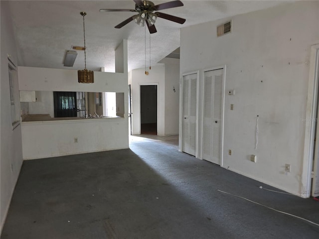 unfurnished living room with lofted ceiling, a textured ceiling, concrete flooring, and ceiling fan