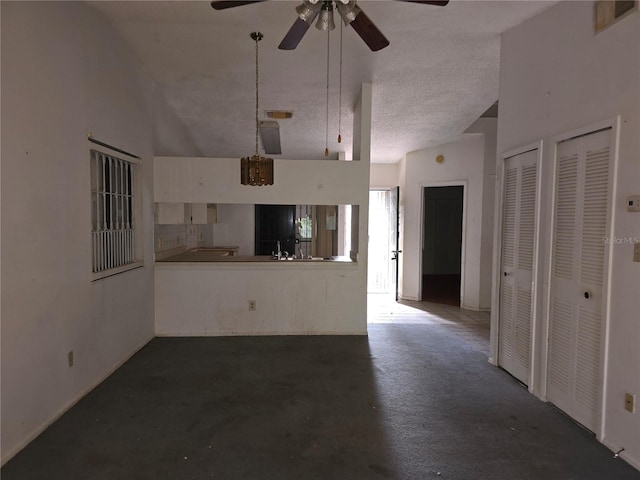 unfurnished living room with a textured ceiling, high vaulted ceiling, and ceiling fan