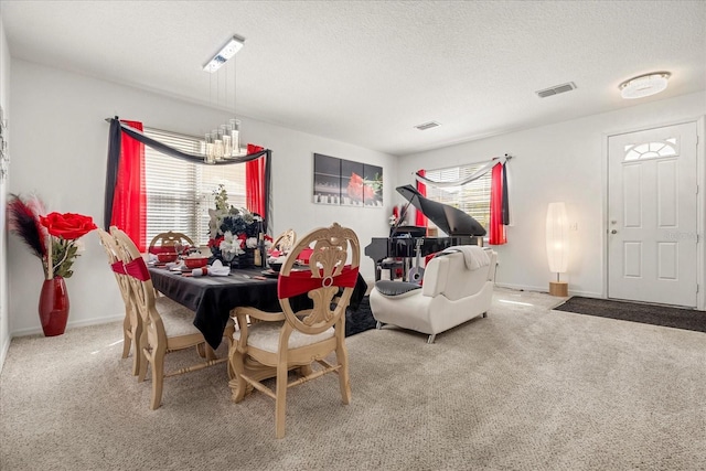 carpeted dining space featuring a chandelier and a textured ceiling