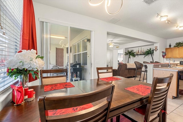 dining room with sink, a textured ceiling, light tile patterned floors, and ceiling fan