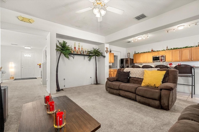 carpeted living room featuring ceiling fan, a textured ceiling, and track lighting