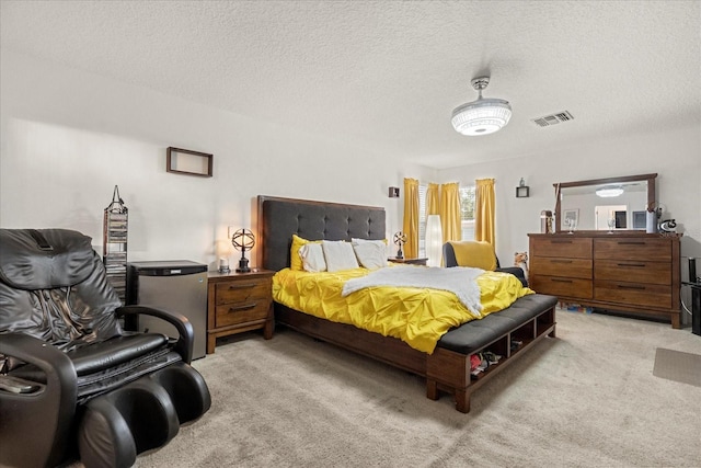 bedroom with a textured ceiling and light carpet