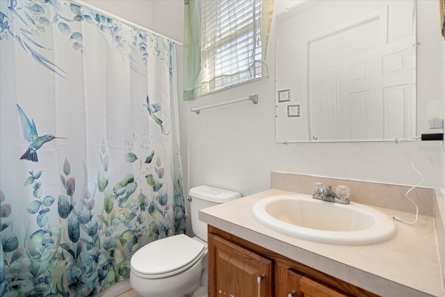 bathroom featuring toilet, vanity, and curtained shower