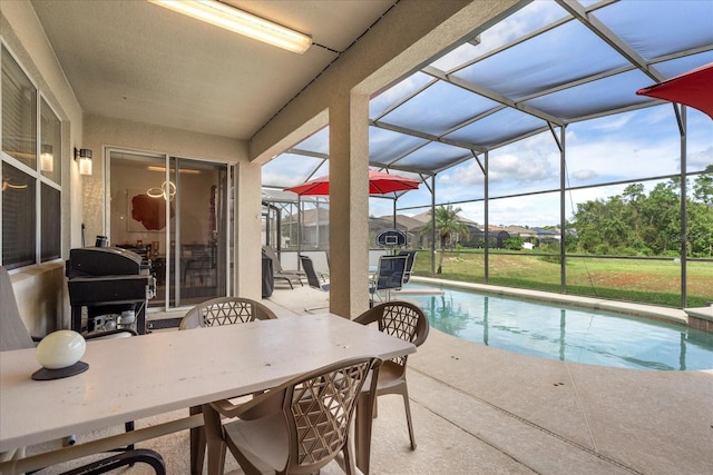 view of pool featuring area for grilling, glass enclosure, and a patio area