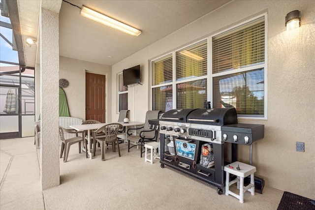 view of patio with a grill and glass enclosure