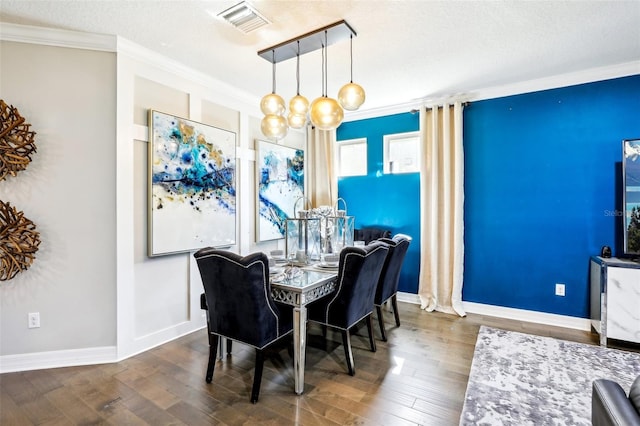 dining room featuring crown molding, a textured ceiling, and dark hardwood / wood-style flooring