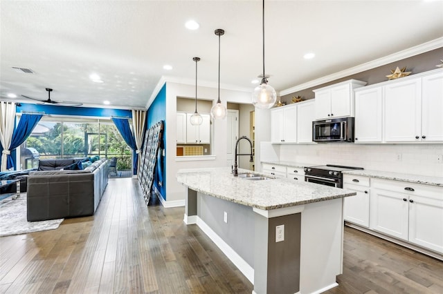 kitchen featuring white cabinetry, stainless steel electric range, sink, and a kitchen island with sink