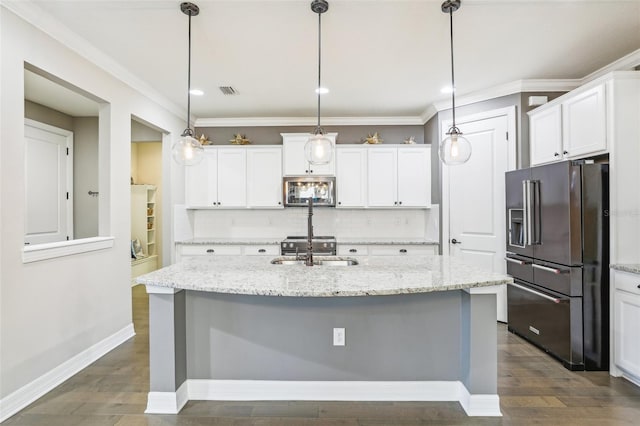 kitchen with white cabinets, light stone countertops, stainless steel appliances, and an island with sink