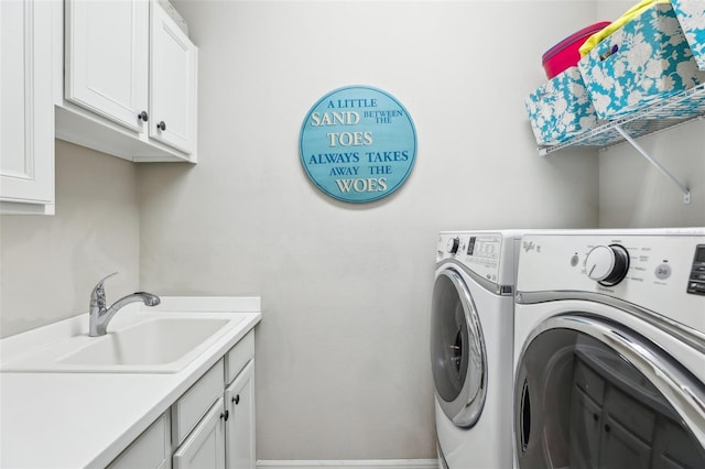 washroom with cabinets, sink, and washer and clothes dryer