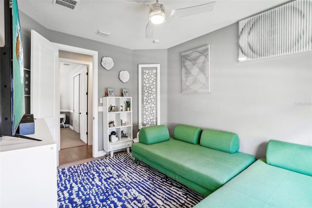 living room featuring wood-type flooring and ceiling fan