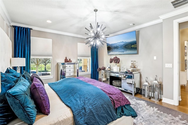 bedroom with a textured ceiling, ornamental molding, an inviting chandelier, and hardwood / wood-style floors