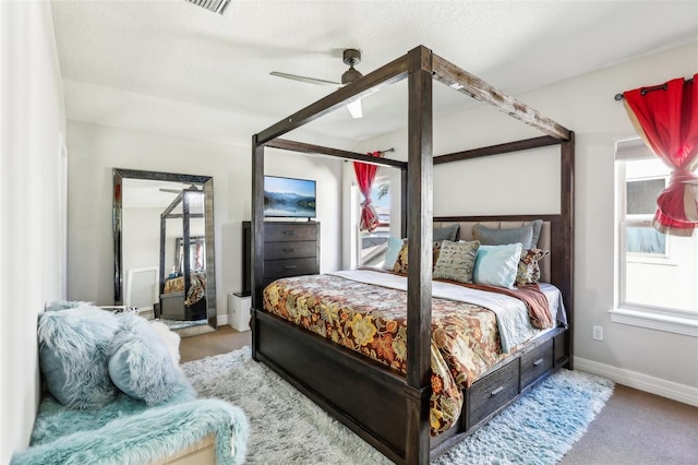 bedroom featuring carpet, ceiling fan, and a textured ceiling