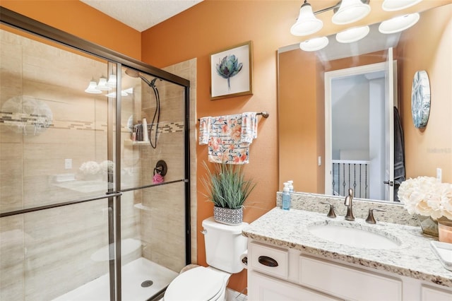 bathroom featuring vanity, toilet, and a shower with door