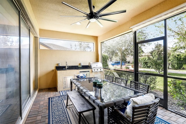 sunroom featuring sink, a healthy amount of sunlight, and ceiling fan