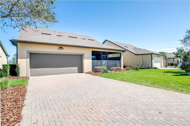 single story home featuring a garage and a front lawn