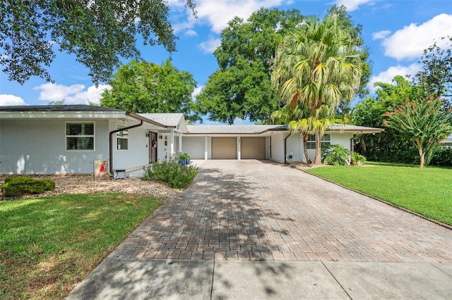 single story home featuring a garage and a front lawn