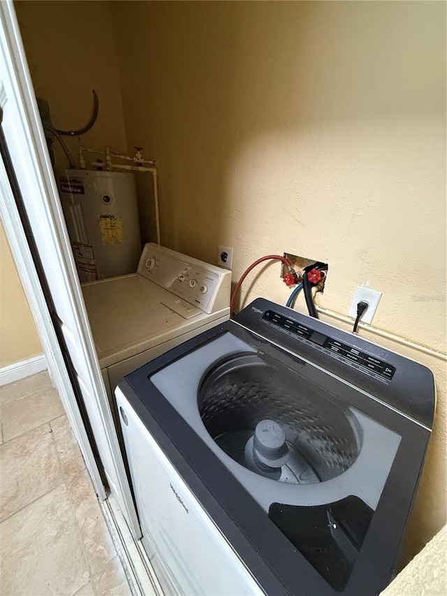 washroom featuring hookup for an electric dryer, water heater, light tile patterned flooring, and washer hookup