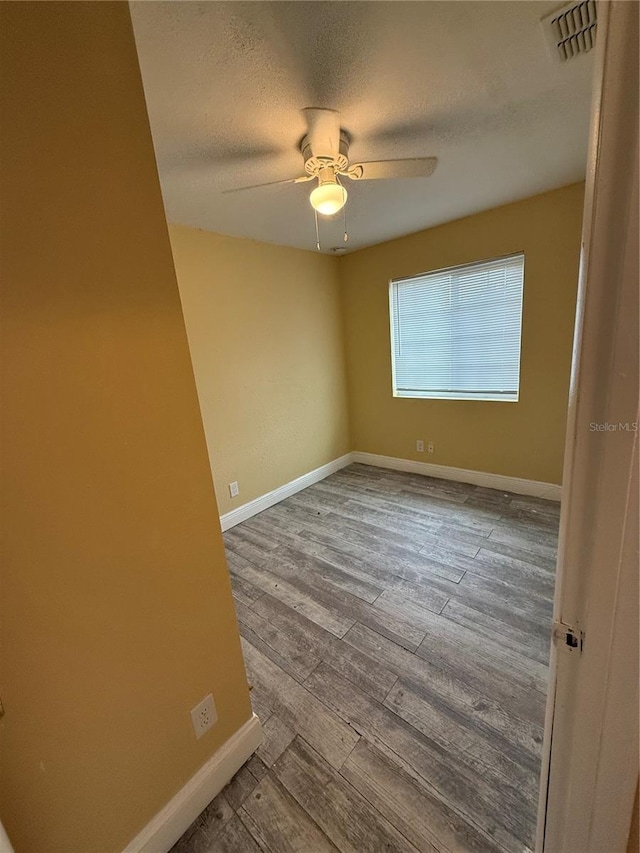 spare room featuring ceiling fan, a textured ceiling, and light hardwood / wood-style flooring