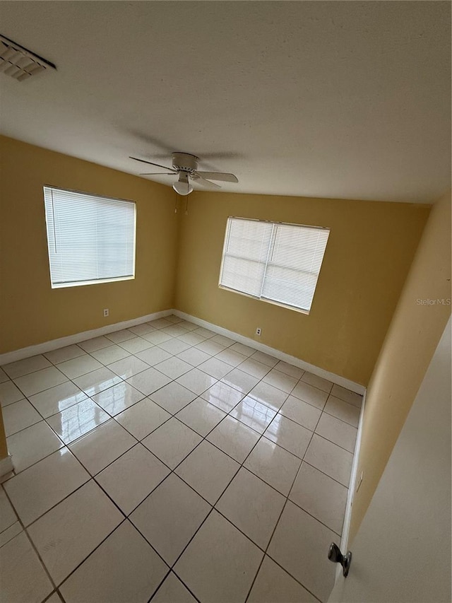 tiled spare room with ceiling fan