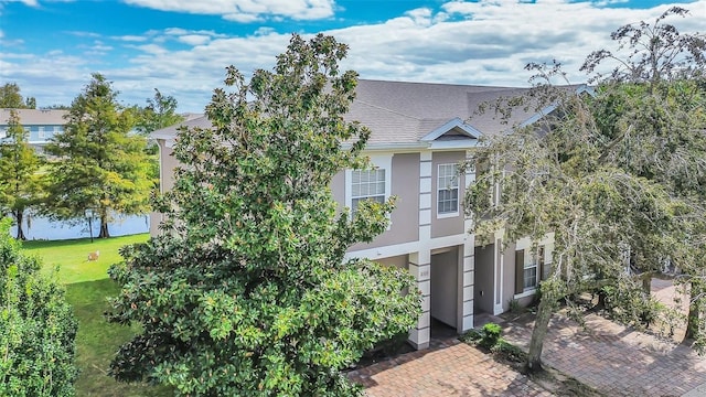 view of property hidden behind natural elements featuring a front lawn