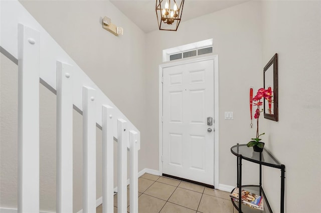 tiled entryway with a notable chandelier