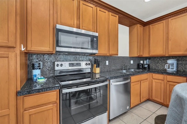 kitchen featuring sink, decorative backsplash, stainless steel appliances, and light tile patterned floors