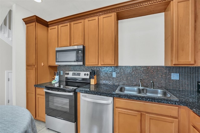 kitchen featuring appliances with stainless steel finishes, sink, light tile patterned floors, and backsplash