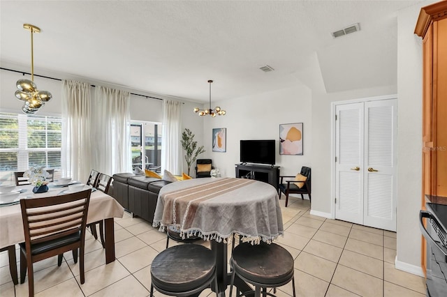 dining area featuring an inviting chandelier and light tile patterned floors