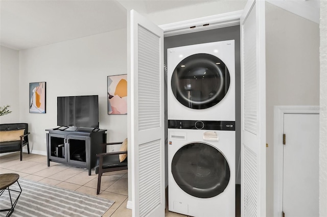 laundry room with stacked washer / drying machine and light tile patterned floors