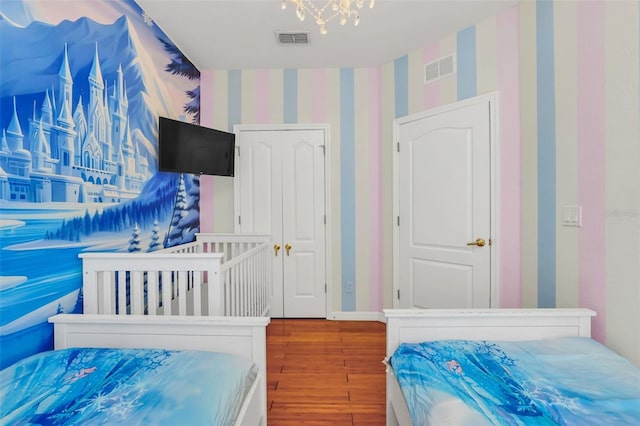 bedroom with a notable chandelier and wood-type flooring