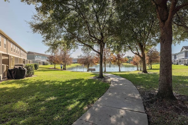 view of community featuring a lawn and a water view