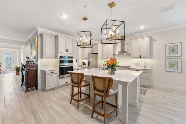 kitchen with pendant lighting, a breakfast bar, light hardwood / wood-style floors, and stainless steel appliances