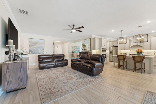 living room featuring ceiling fan, light hardwood / wood-style flooring, sink, and ornamental molding