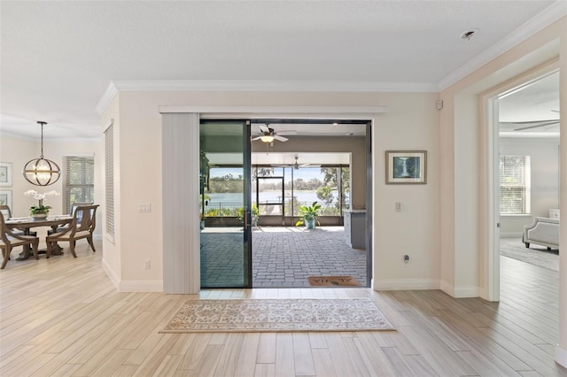 interior space with ornamental molding, light wood-type flooring, and a healthy amount of sunlight