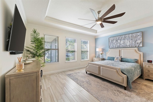 bedroom with a raised ceiling, ceiling fan, light hardwood / wood-style floors, and ornamental molding