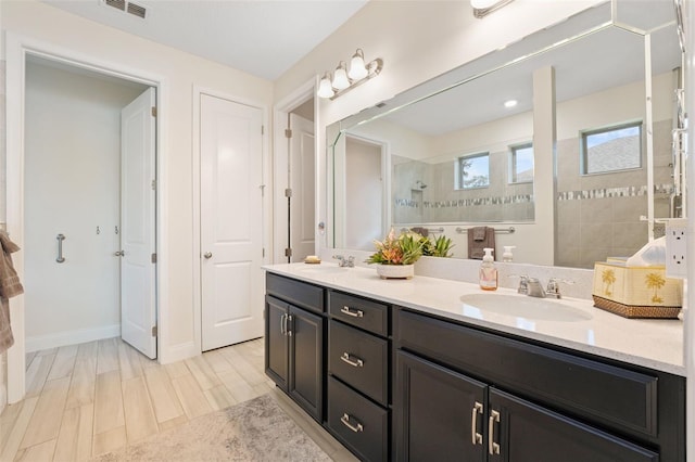 bathroom featuring vanity and tiled shower