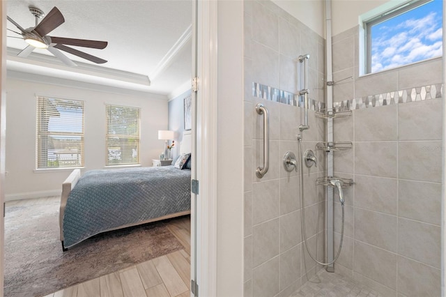 bathroom featuring tiled shower, hardwood / wood-style floors, plenty of natural light, and ornamental molding