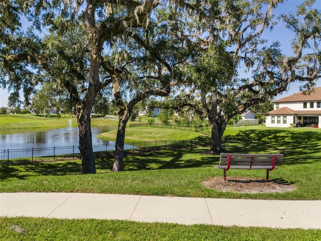 view of community with a lawn and a water view