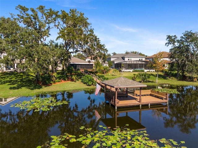 view of dock with a yard and a water view