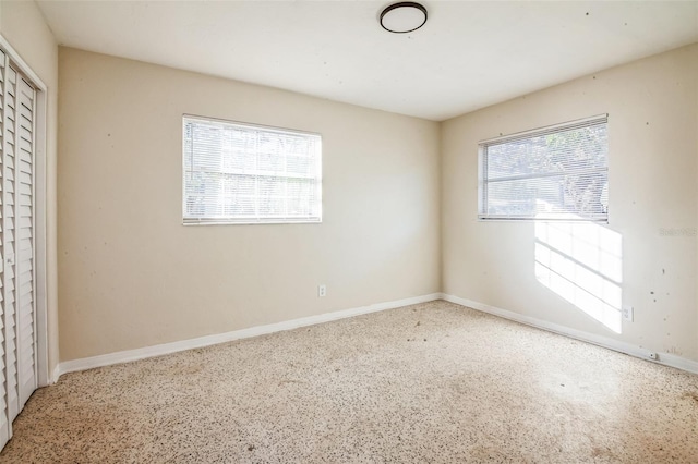 unfurnished bedroom with multiple windows and a closet