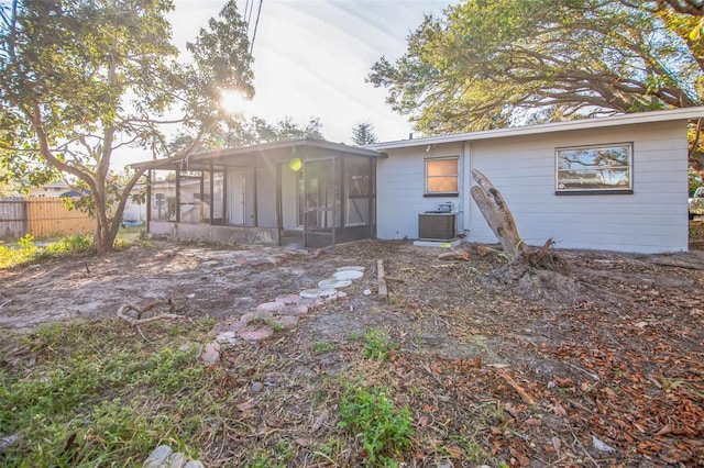 rear view of house featuring central AC and a sunroom