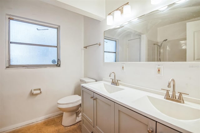 bathroom featuring a shower, a wealth of natural light, vanity, and toilet