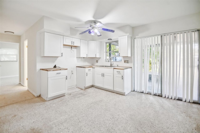 kitchen with white cabinets, ceiling fan, and sink