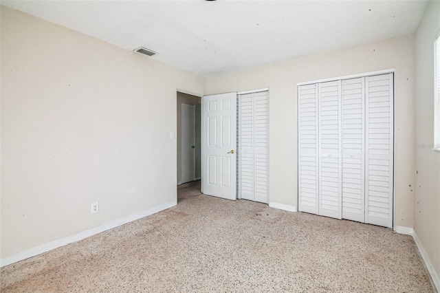 unfurnished bedroom featuring multiple closets